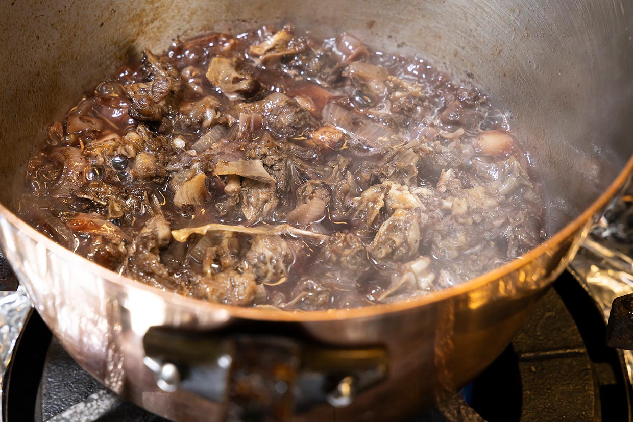 仔鳩の骨にマデラ酒・赤ワインを加える